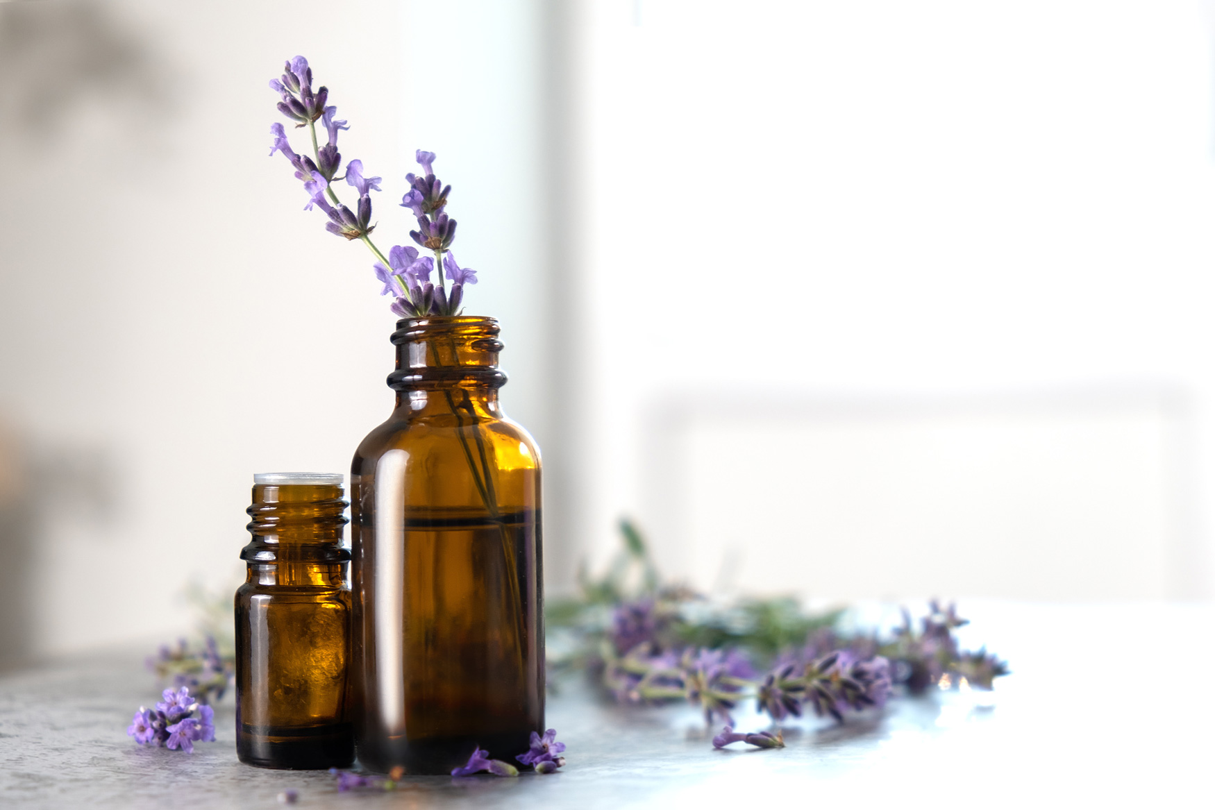 Essential oil bottles sitting on a table with lavender sprigs
