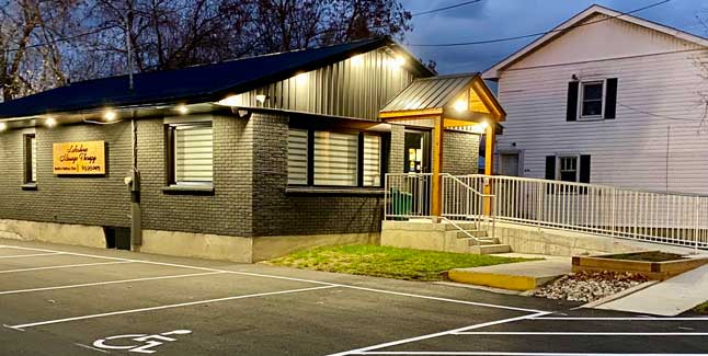 Lakeshore Massage Therapy building with grey brick and wood beamed door overhang